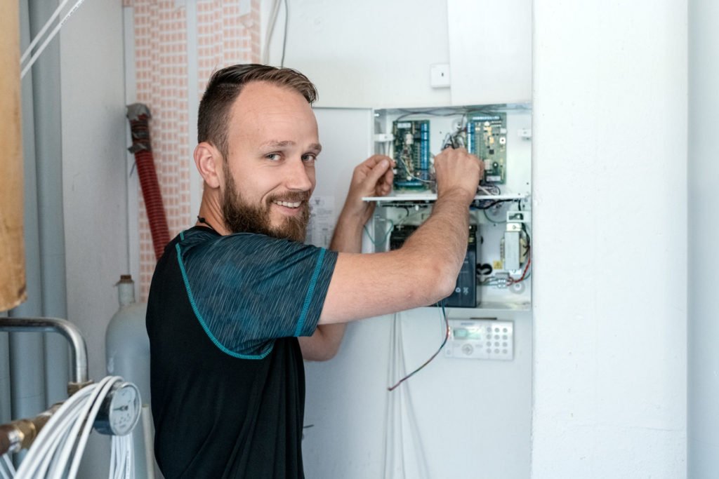 Elektriker arbejder med ledninger i kontrolboks