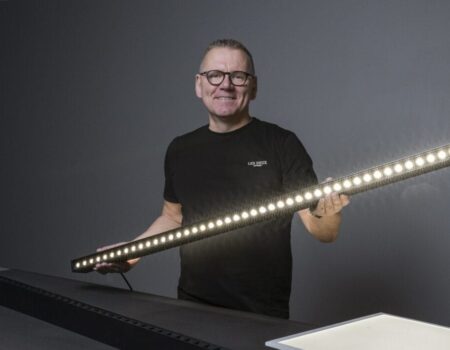 Person med LED-lysestav i gråt rum