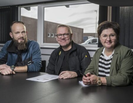 Tre personer ved mødebord