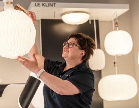 Kvinde justerer lampe i butik