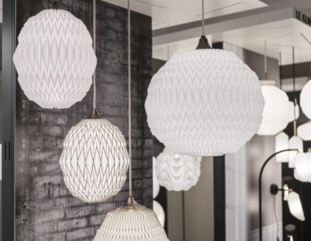 Moderne papirlamper hænger fra loft ved Le Klint udstilling.