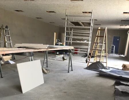 Byggeplads under renovering med stilladser og materialer.