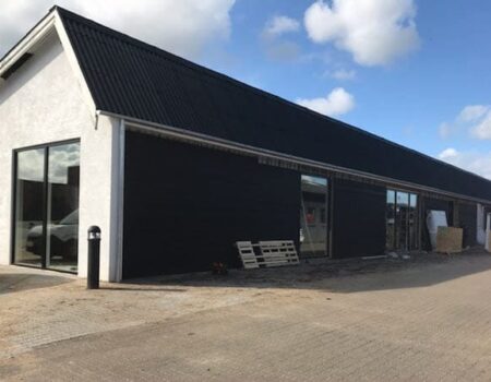 Industribygning med store vinduer og sorte vægge